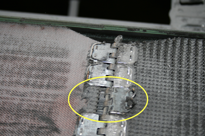 Le joint métallique de type "Alligator" de cette courroie de convoyeur se compose de plusieurs attaches. L’une d’entre elles est arrachée, ce qui induit un problème de qualité au niveau des produits qui  sont transportés par ce convoyeur. De plus, il y a augmentation des contraintes au niveau des autres attaches ce qui va inévitablement engendrer le bris de la courroie si l'on ne corrige pas la situation.